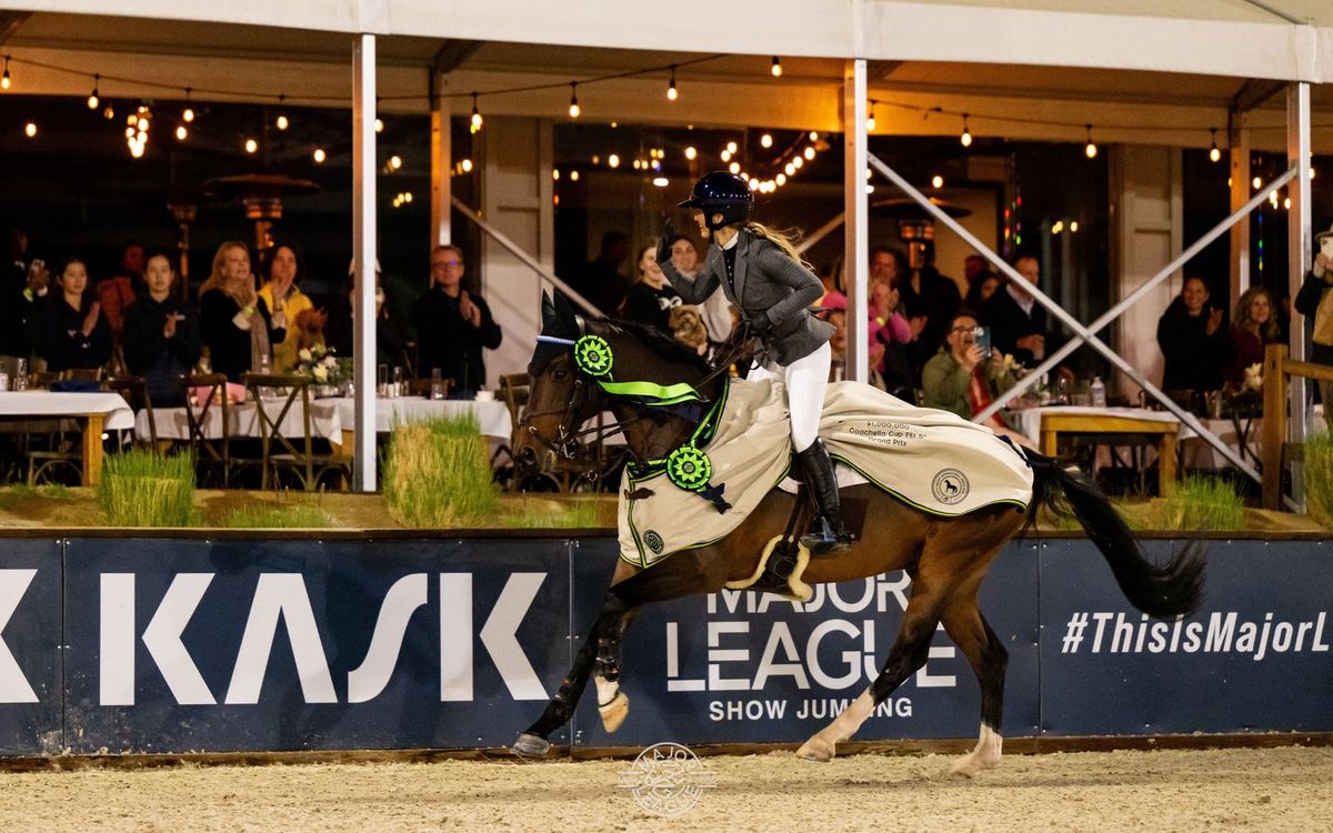 A rider clears a fence under the lights in the Coachella Cup at Desert International Horse Park