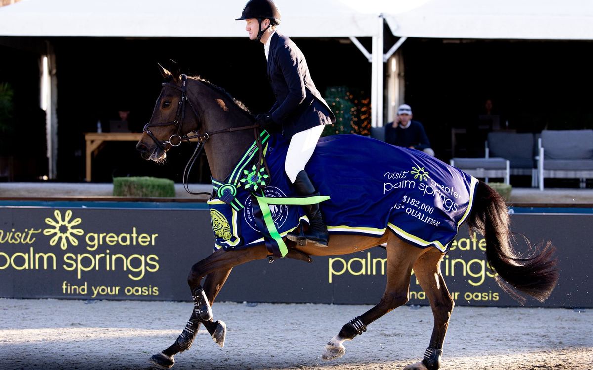 A horse in an MLSJ cooler walks out of the arena at Desert International Horse Park