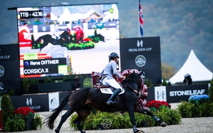 A rider jumps in front of the Highlands scoreboard