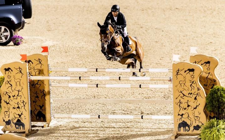 A horse and rider over a fence at the Kentucky International
