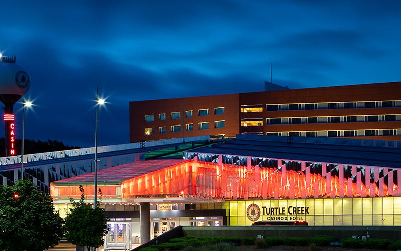 Turtle Creek Casino & Hotel at night, with the hotel tower behind the casino entrance
