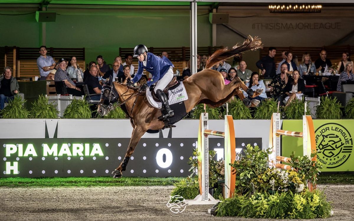 A horse jumps in front of VIP guests ringside at MLSJ Toronto