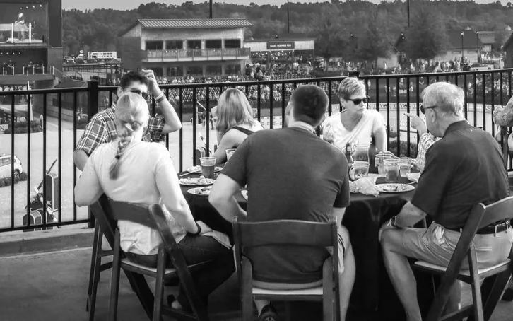 Guests dining at the rail overlooking the arena at Tryon International